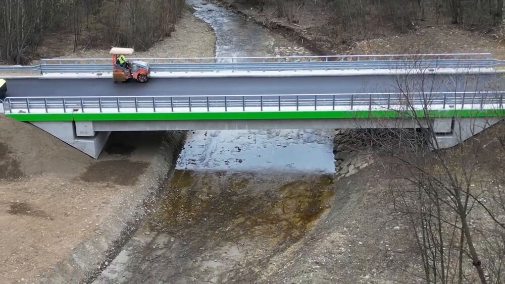 Jest pierwsza warstwa asfaltu na moście Jadamwola – Czarny Potok. Finał inwestycji wcześniej niż zakładano [WIDEO]